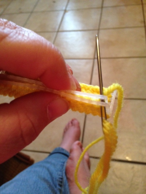 Whip stitching two long sides of my butter toy together.  The corner gets three stitches for coverage, then move on to the next hole, then the next until the end of the row.