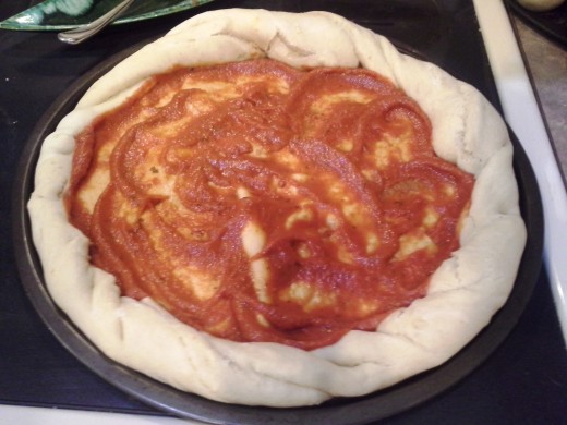 Step Fifteen: When your pizza crust is set, spread pizza sauce evenly over the top