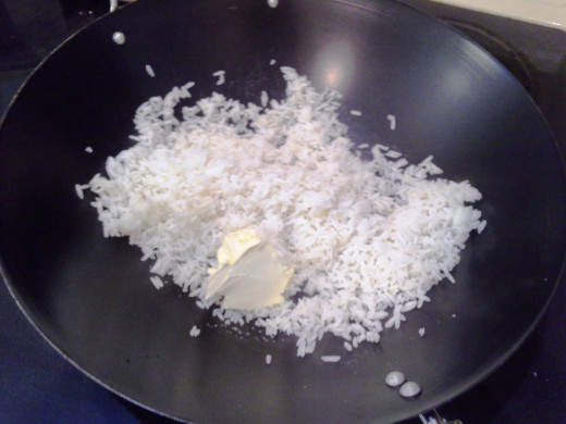 Step Six: Add your butter to the rice in your Wok and mix