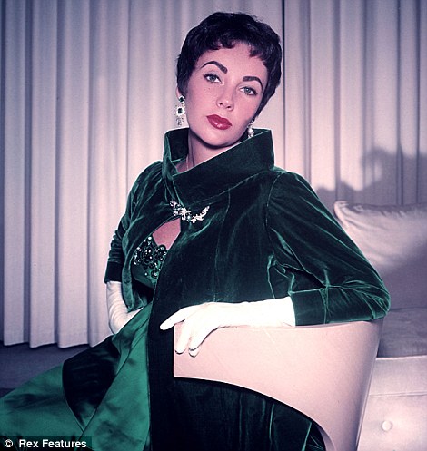 Elizabeth Taylor, showing off rich jewel tones in her dress and coat.