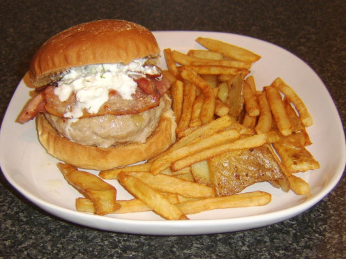 Pork, sage and onion burger with bacon and cottage cheese served with fries and potato skins