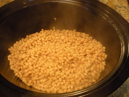 Dump the boiled beans on top, and pour the boiling or very hot water over the top; no need to stir