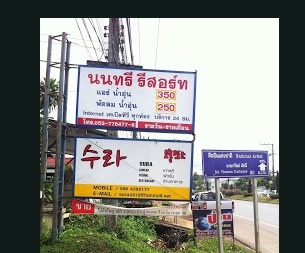 From the main road heading to Mae Sai, turn left on the street after the Korean restaurant advertised on the board. Beside the advertisement is a blue sign with the artist's name.