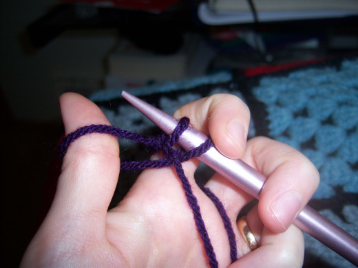 Once you loop the yarn from your pointer and draw the needle through the hoop still attached to your thumb, it will look like this.