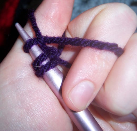 Drawing the needle with the third stitch through the loop held by the thumb.