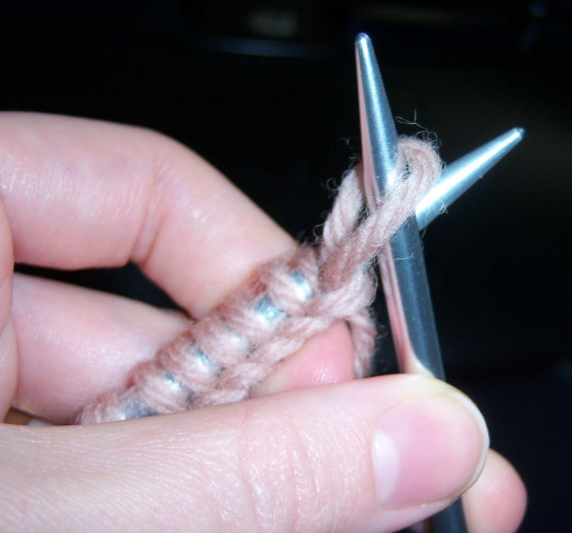 Pull the loop through the stitches and transfer it to the other needle.