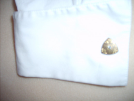 This triangular gold cufflink has a rhinestone in the center.  It looks wonderful with brown or khaki.  