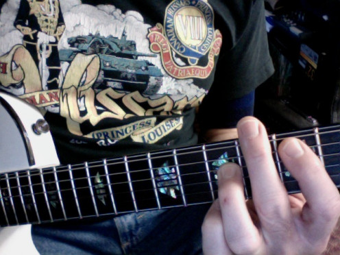 Using the edge of the second finger to mute the sixth string for Root 5 Power Chords