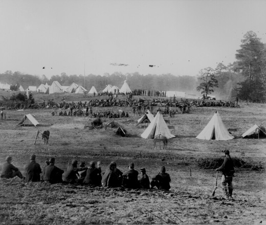 Rebel prisoners are held in a temporary prison area while Union guards relax in the foreground