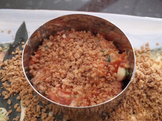Add a few heaping tablespoons of the salmon mixture and pat it down with a spoon to make a patty. Then sprinkle the top with more whole wheat panko breadcrumbs.