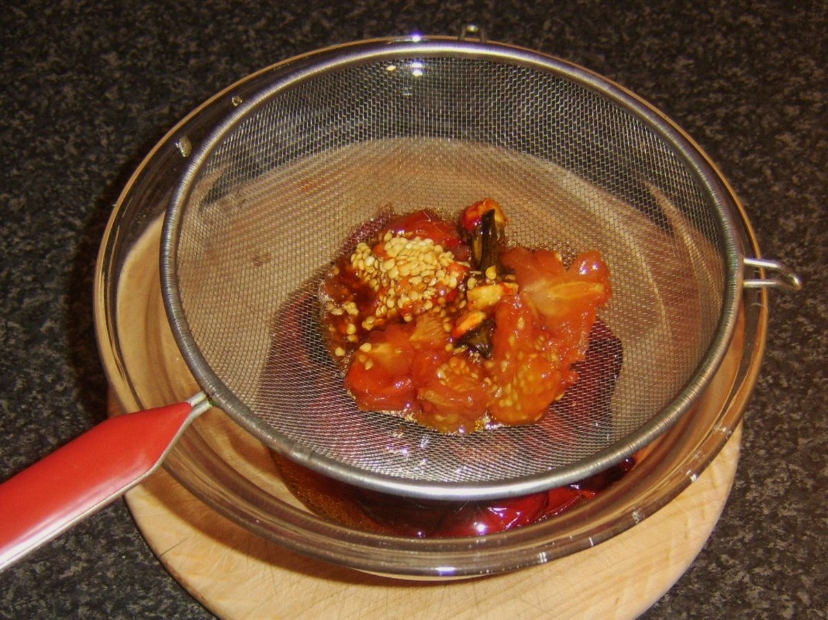 Straining juices from roasted peppers and tomatoes