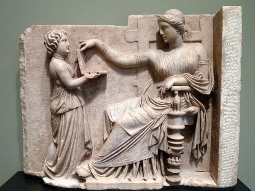 Gravestone of a Woman with Her Attendant (Greek, c. 100 BC). The hinged object was possibly a jewelry box, mirror, or wax writing tablet (probably not a laptop computer).Uploaded by Marcus Cyron Author;Dave & Margie Hill / Kleerup from Centennial, CO