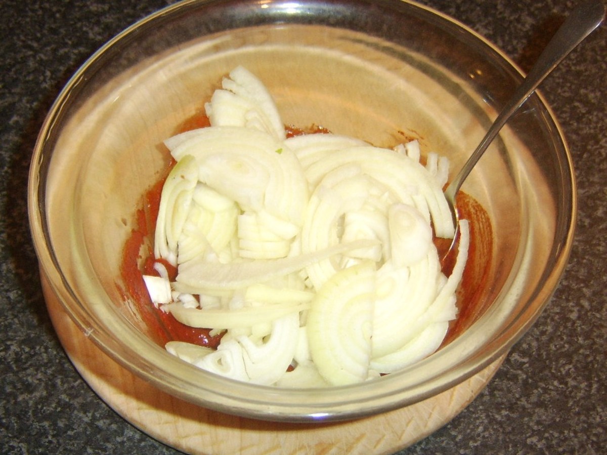 Sliced onions are added to Indian spiced sauce