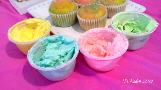 Separate Icing into small bowls and drop separate colors of the food coloring into each bowl.  Start with one drop at a time to achieve the color you want.