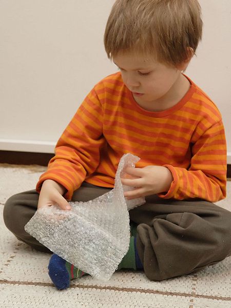 Boy playing with bubble wrap