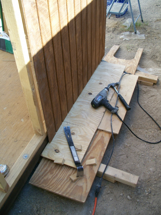 Installing the first piece of siding on a side wall.