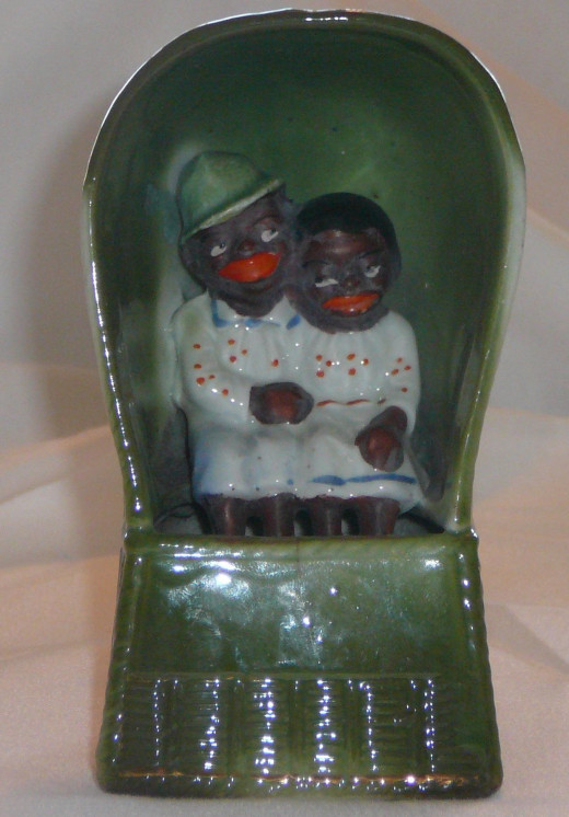 Couple holding hands sitting in a wicker chair. Only one I've seen of its kind. 4 3/4" x 2 3/8" - Paid $43.