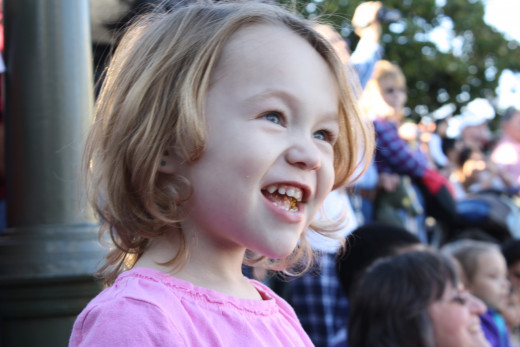 Sweets (age 3) watches a parade at the Magic Kingdom.