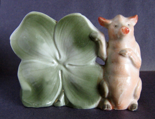 Occasionally pigs are featured with shamrocks. They may be on the pin dish itself or sometimes in the wheels of cars. This item just sold on ebay for $62. Rare.