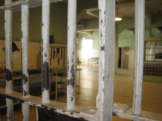 Through the bars on the left, the board with the black knife silhouettes can be seen. 