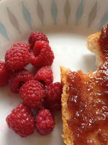 Raspberries with raspberry preserve on a slice of homemade bread.  A very yummy breakfast!