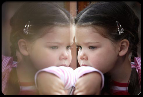 Overobsession with minor things is a common  is sign of a baby being autistic. This child is obssessed with her image in the window pane