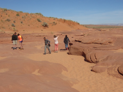 People in wash with Lower Antelope Canyon located in upper right