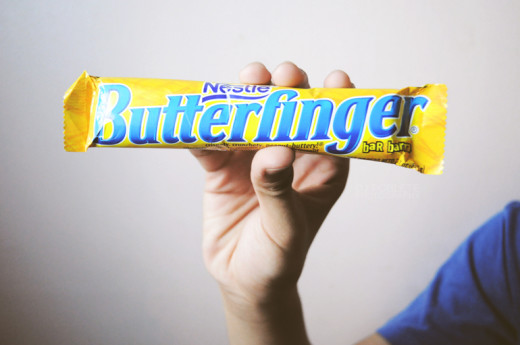 Butterfinger is a candy bar that consists of a flaky, orange colored center that tastes like peanut butter.