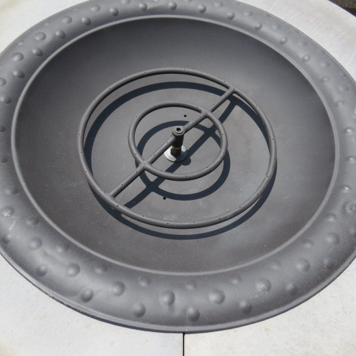 Round fire ring in bowl insert on stone surround.