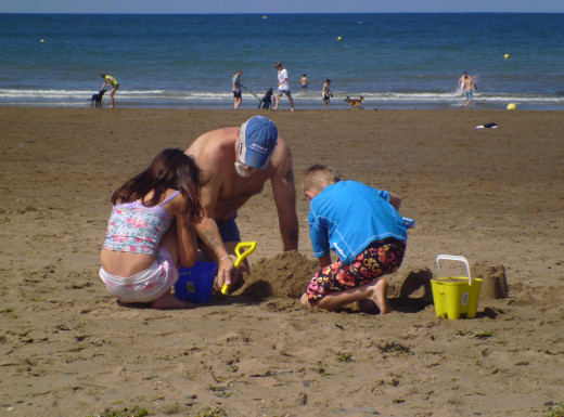 Dai and the kids building sandcastles.