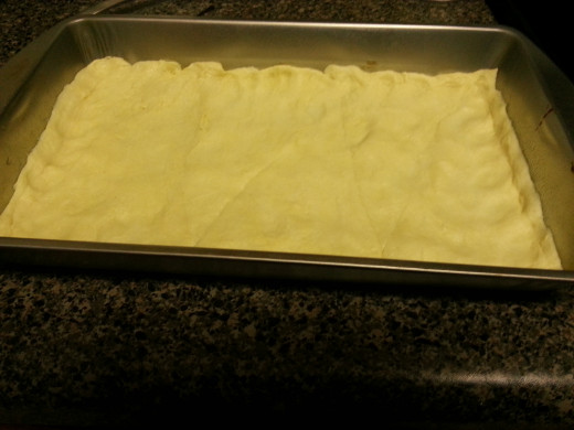 Crescent rolls pressed into greased  pan.