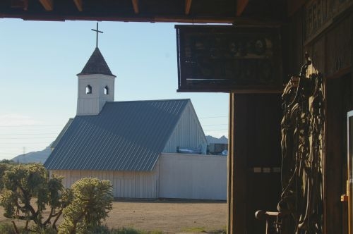 View of the chapel from inside the barn. On the right, faintly seen, are bridles and other leather devices.
