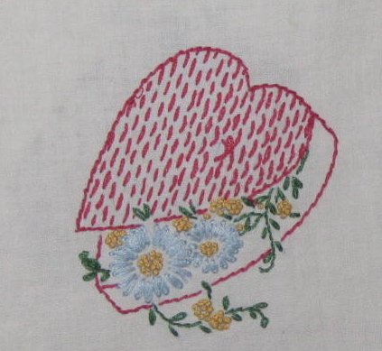 Card suits are embroidered on this vintage tablecloth.