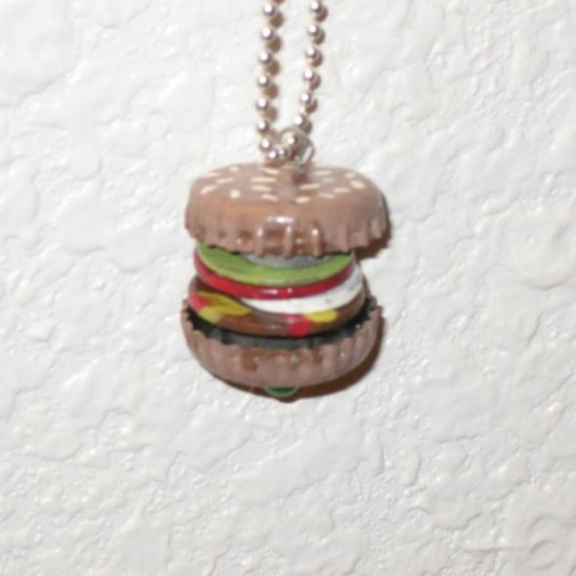 A found object hamburger pendant I made. With junk.