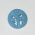 Decorative blue open design or filigree button. Two stars on either side of a torch in the middle.