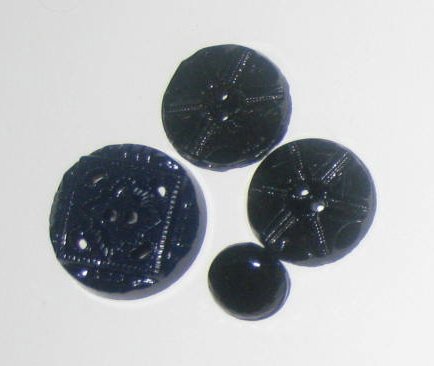 Four beautiful black pressed glass buttons.