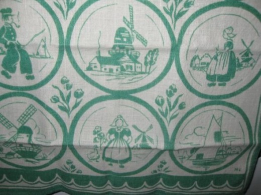 VIntage tea towel with Dutch designs:  windmills, Dutch girl, Dutch boy, and more.