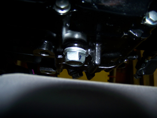 The oil filter bolt is located on the bottom of the engine nearest to the exhaust. Place an oil pan directly under the bolt to catch the draining oil.
