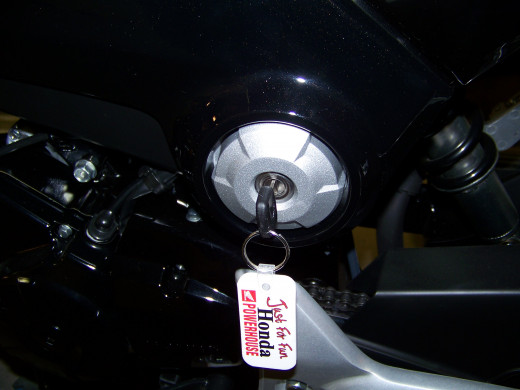 The battery compartment is under the seat on the Grom. You use the key to open the compartment under the seat.