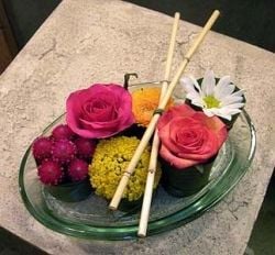 A floral arrangement made to look like a plate of sushi 