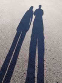 A couple casting long shadows 