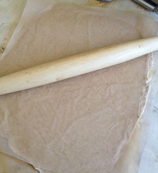 Roll out the dough between two pieces of parchment paper