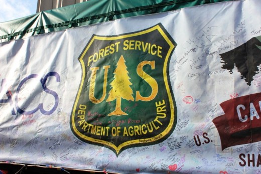 People are encouraged to sign the tarp as the tree stops along the way to Washington, DC.