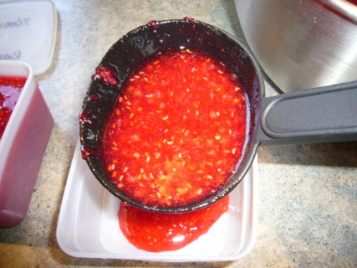 Ladle the jam into the containers.