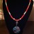 Coral and teal beads highlight the colors in the focal bead.