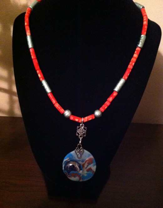 Coral and teal beads highlight the colors in the focal bead.
