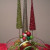 Three tree figurines in back, small bowl with ornaments in front, glitter fronds and large ornament accent.