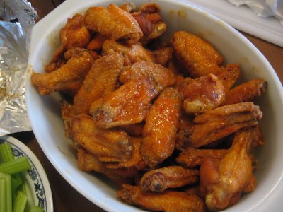 Chicken wing sauce being added to the wings.
