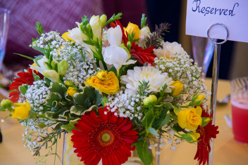 Centerpiece with gerber daisies, dahlias, freesia, spray yellow roses, gypsophilia, pittosporum and lots of sliced lemons. 