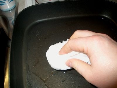 Spread out oil with paper towel and soak up access.